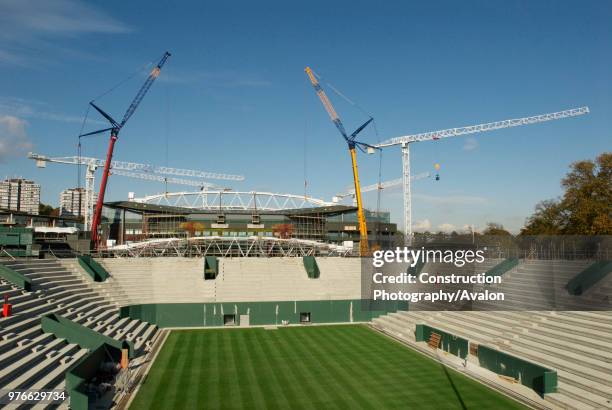 View from new No 2 Court as two cranes work in tandem to lift roof trusses on to fixed roof of Centre Court, All England Lawn Tennis Club, Wimbledon,...