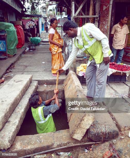 workers cleaning drains - david talukdar stock pictures, royalty-free photos & images