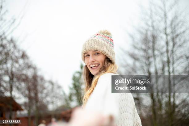 young woman enjoying the snow - bobble hat stock pictures, royalty-free photos & images