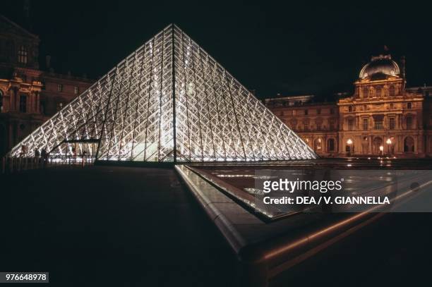 The Louvre pyramid and the Richelieu wing at night, Paris , France.