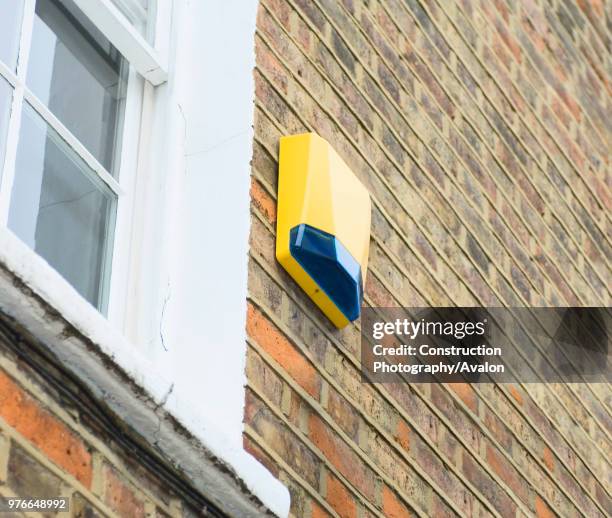 Burglar alarm fitted to house, low angle.