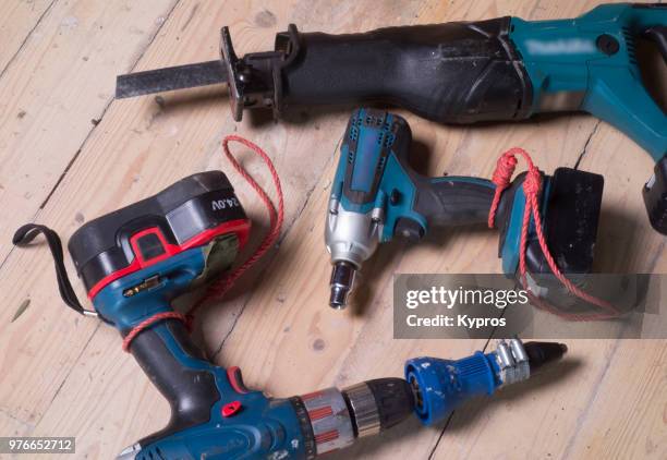 europe, greece, 2018: view of 24 volt cordless drill fitted with unusual rivet driver with cordless reciprocating saw and impact wrench - インパクトレンチ ストックフォトと画像