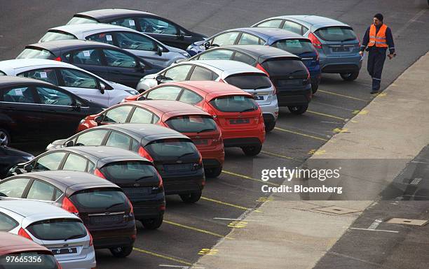 An employee inspects new Ford Fiesta automobiles outside the Ford Motor Co.'s factory in Cologne, Germany, on Thursday, March 11, 2010. Ford Motor...