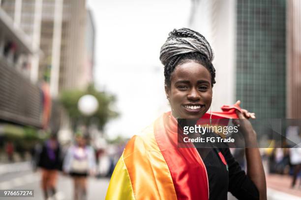 afro frau winken regenbogenfahne - gay flag stock-fotos und bilder