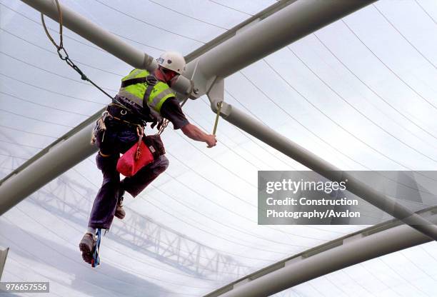 Abseiler checking the steel structure of Kings Hospital roof, Camberwell, London.