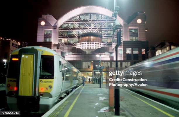 Night at Charing Cross Station, London and a South Eastern Trains Class 375 Electrostar awaits to depart whilst a Class 466 speeds away .