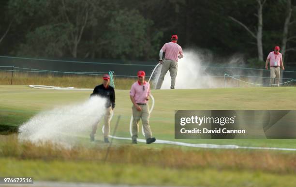 Greenstaff hand water the eighth green during the third round of the 2018 US Open at Shinnecock Hills Golf Club on June 16, 2018 in Southampton, New...