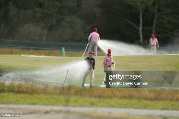 Greenstaff hand water the eighth green during the third round of the 2018 US Open at Shinnecock Hills Golf Club on June 16, 2018 in Southampton, New...