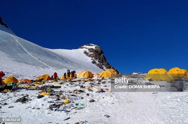 This picture taken on May 21, 2018 shows discarded climbing equipment and rubbish scattered around Camp 4 of Mount Everest. - Decades of commercial...