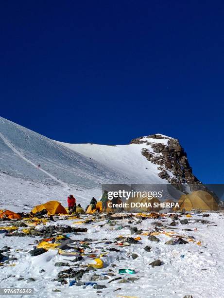 This picture taken on May 21, 2018 shows discarded climbing equipment and rubbish scattered around Camp 4 of Mount Everest. - Decades of commercial...