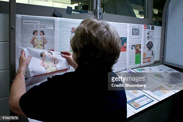Linda Kerst compares copies of USA Today newspapers that just came off the printing press inside the main Denver Newspaper Agency printing facility,...