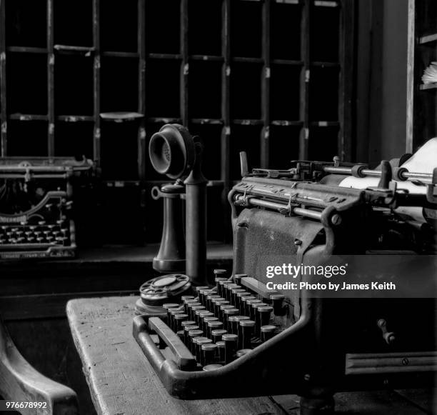 a typical office scene of long ago with its manual typewriters, cubby holes for sorting, and antique two piece telephone - antique phone stock pictures, royalty-free photos & images