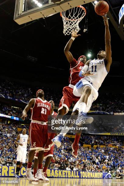 John Wall of the Kentucky Wildcats drives for a shot attempt against Tony Mitchell of the Alabama Crimson Tide during the quarterfinals of the SEC...