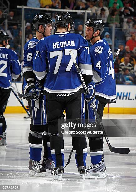 Kurtis Foster of the Tampa Bay Lightning talks with teammates Victor Hedman and Vincent Lecavalier during a break in the action against the Atlanta...