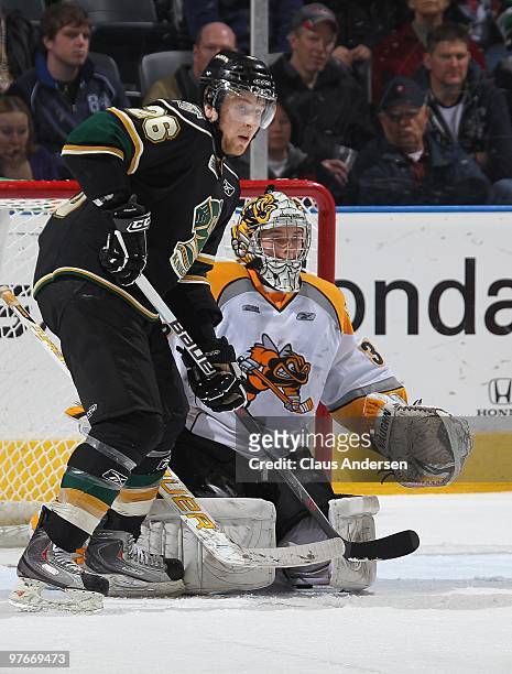 Colin Martin of the London Knights waits to tip a shot next to Shayne Campbell of the Sarnia Sting in a game on March 10, 2010 at the John Labatt...
