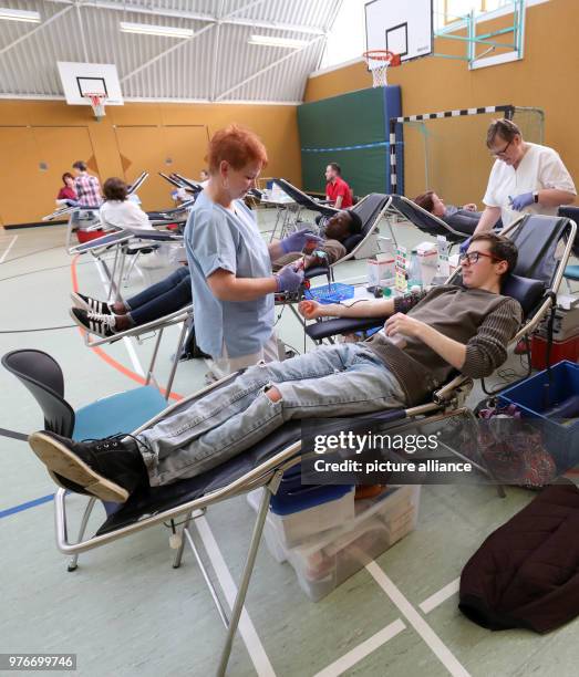 April 2018, Germany, Rostock: Vocational students donate 500 millilitres of blood at a gym of the vocational school 'Alexander Schmorell' at the...