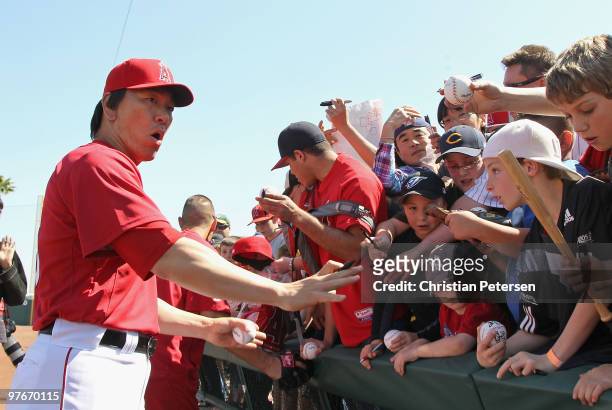 Hideki Matsui of the Los Angeles Angels of Anaheim reacts as the fence holding back fans breaks before the MLB spring training game against the...