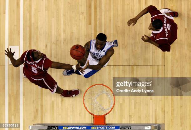 Eric Bledsoe of the Kentucky Wildcats drives for a shot attempt against Tony Mitchell and Mikhail Torrance of the Alabama Crimson Tide during the...