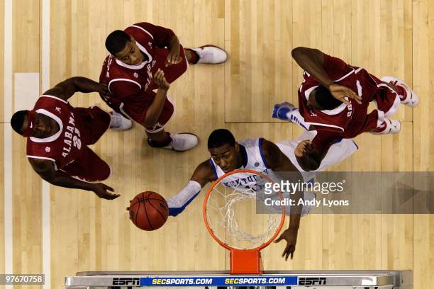 John Wall of the Kentucky Wildcats drives for a shot attempt against Senario Hillman, Mikhail Torrance and Jamychal Green of the Alabama Crimson Tide...