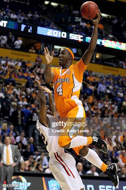 Wayne Chism of the Tennessee Volunteers drives to the basket against Chris Warren of the Mississippi Rebels during the quarterfinals of the SEC Men's...