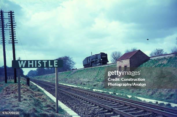 Re-built Bulleid Light Pacific heads, light engine, across Battledown Flyover west of Basingstoke. The engine is on the up line from Bournemouth and...