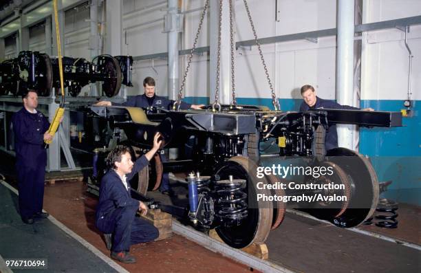 Completed bogie frames are dropped onto the wheels at BREL, Derby, circa 1993.