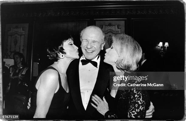 American playwright Terrence McNally is kissed on each cheek by Chita Rivera and Joan Rivers at an event in January 1998 in New York City, New York.