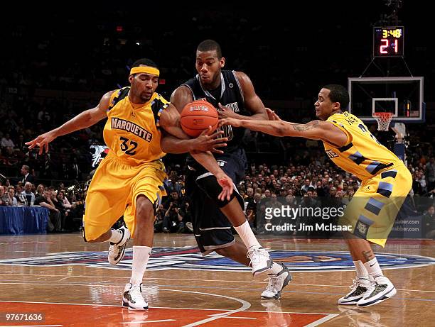 Greg Monroe of the Georgetown Hoyas drives through Lazar Hayward and Maurice Acker of the Marquette Golden Eagles during the semifinal of the 2010...