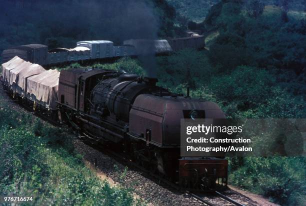 An East African Railways Mountain Class 2-8-4 + 4-8-2 Garratt climbs the steep coastal escarpment out of Mombasa on the first lap of its 330 mile...