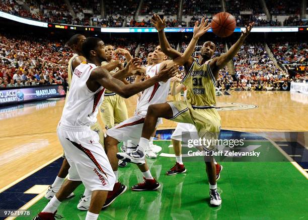 Gani Lawal of the Georgia Tech Yellow Jackets pulls in a rebound between Greivis Vasquez and Landon Milbourne the University of Maryland Terrapins in...