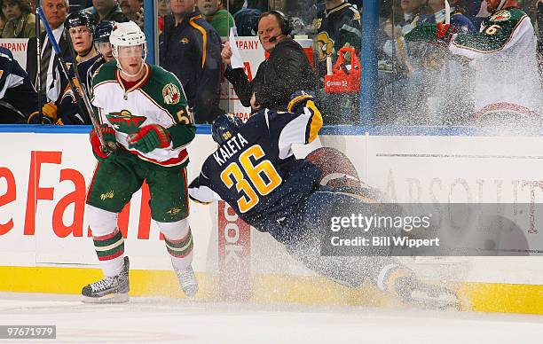 Nick Schultz of the Minnesota Wild steps out of the path Patrick Kaleta of the Buffalo Sabres as Kaleta attempts to check Schultz into the boards on...
