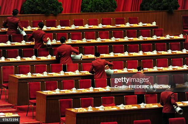 Hostesses fill teacups ahead of the arrival of delegates and top leaders at the closing session of the Chinese People's Political Consultative...