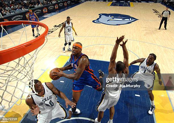 Al Harrington of the New York Knicks drives to the basket between Darrell Arthur and Sam Young of the Memphis Grizzlies on March 12, 2010 at...