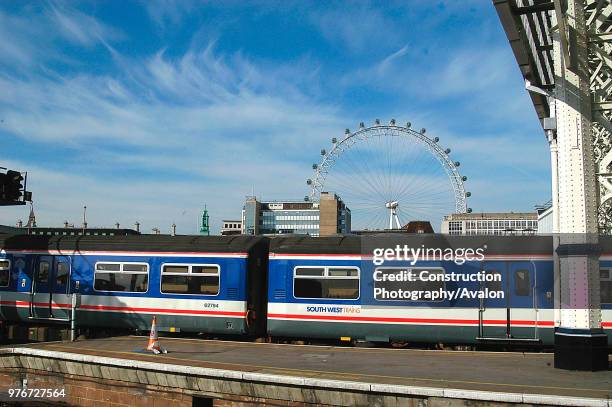 Platform scene at London Waterloo with a suburban service at the platform and the London Eye in the background. 2003, United Kingdom.