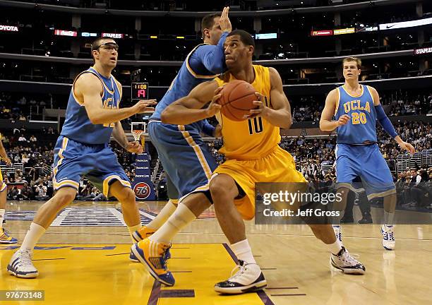 Jamal Boykin of the Cal Golden Bears is defended by Reeves Nelson and Nikola Dragovic of the UCLA Bruins in the first half during the Semifinals of...