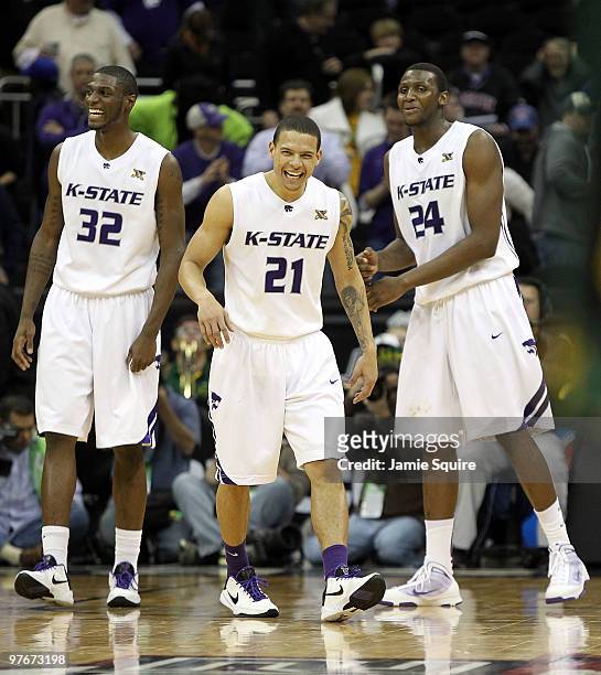 Jamar Samuels, Denis Clemente, and Curtis Kelly of the Kansas State Wildcats celebrate as the Wildcats defeat the Baylor Bears 82-75 to win their...