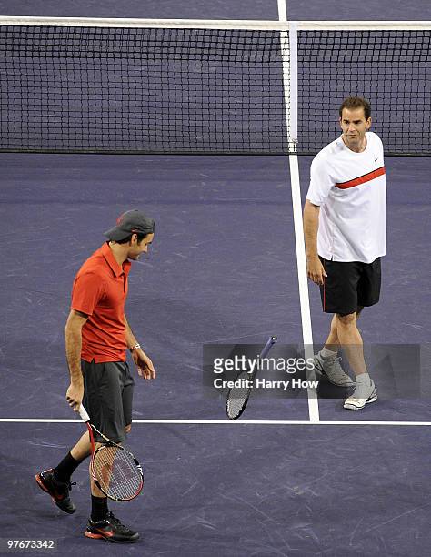 Pete Sampras of the United States tosses his racquet with Roger Federer of Switzerland in their match against Andre Agassi of the United States and...