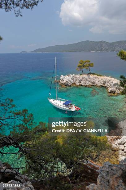 Sailing boat moored in a creek at Cape Amarandos, Skopelos Island, Northern Sporades, Greece.