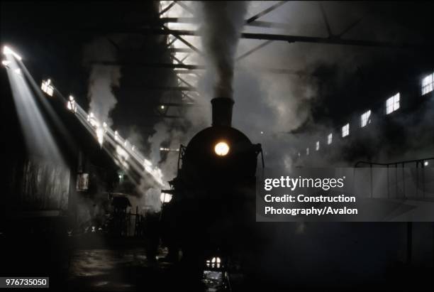 Sunlight smoke and shadow. A Chinese SY Class industrial Mikado 2-8-2 resides amid the smokey gloom on shed at Anshan Iron & Steel Works. Some 1750...