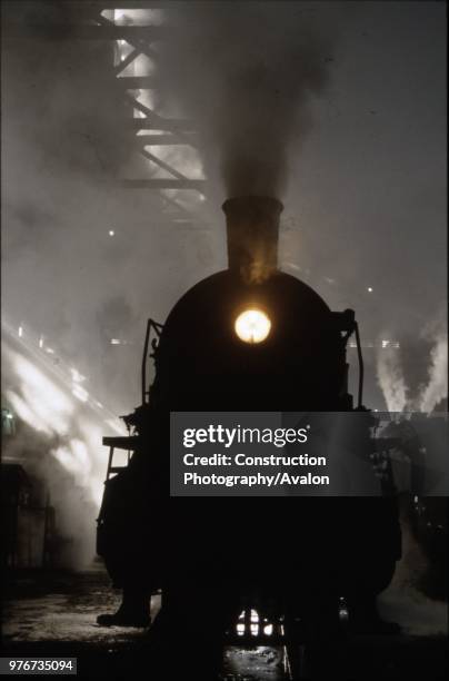 Sunlight smoke and shadow. A Chinese SY Class industrial Mikado 2-8-2 resides amid the smokey gloom on shed at Anshan Iron & Steel Works. Some 1750...