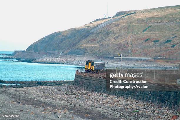 The barrenness of the Cumbrian Coast is well seen as a single Class 153 unit curves into Parton with a Whitehaven - Carlisle local passenger service....