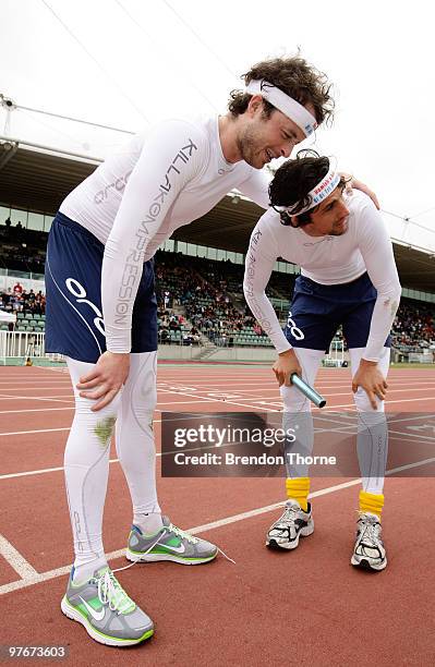 Comedians Andy Lee and Hamish Blake take a breather after competing in a exhibition 4x400 metre Relay during day three of the 2010 Australian Junior...