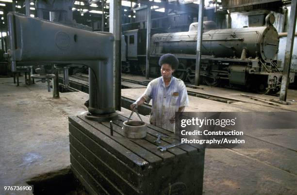 The Craven cutting machine at Accra Steam sheds. Charlotte Sowah takes measurements as a Vulcan Foundry 4-8-2 complete with Giest chimney stands in...