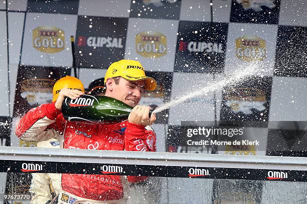 Lee Holdsworth of the Fujitsu Racing/GRM team celebrates with champagne getting second place in race one of the Clipsal 500, which is round three of...