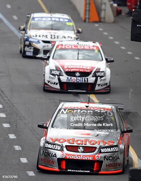 Jamie Whincup of the TeamVodafone team leads Garth Tander of the Toll Holden Racing Team and James Courtney of the Jim Beam Racing Team during race...