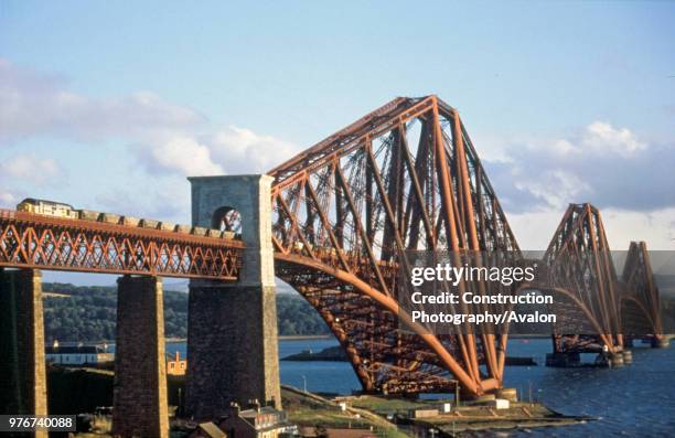 The Forth Bridge over the Firth of Forth with a coal train crossing hauled by a Class 37 diesel electric, circa 1993.