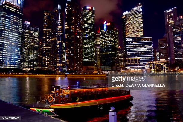 Boat on the Singapore River, skyscrapers at night, Singapore.