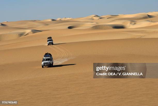 Two off-road vehicles in the sandy dunes in the Western desert, Sahara desert, Egypt.