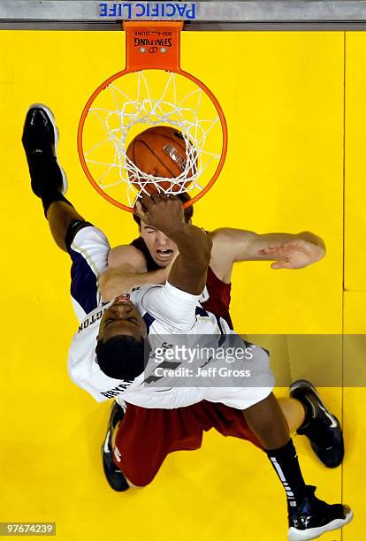 Abdul Gaddy of the Washington Huskies dunks over Andrew Zimmermann of the Stanford Cardinal in the second half during the Semifinals of the Pac-10...