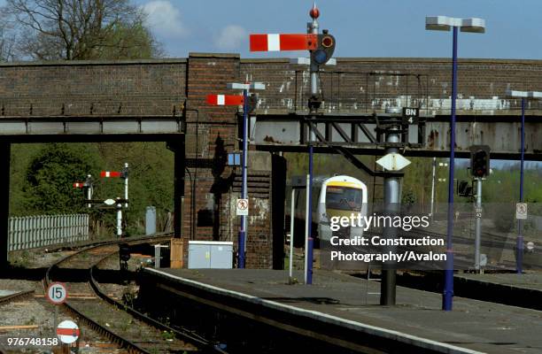 Traditional semaphores at Banbury station with a Class 168 DMU approaching with a Chiltern Trains service, United Kingdom.